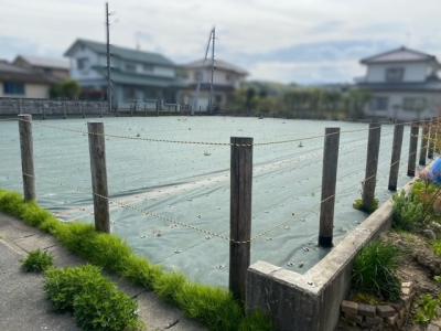 対象物件の画像です。更地の上を防草シートで覆い、四方を木杭とロープで囲っています。
